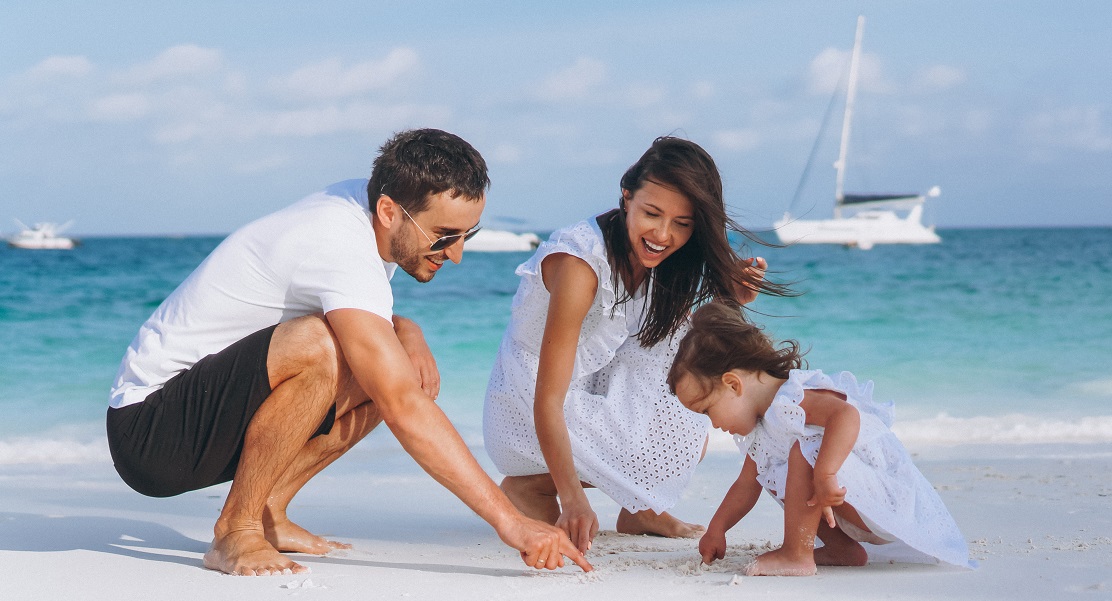 Young family with little daugher on a vacation by the ocean
