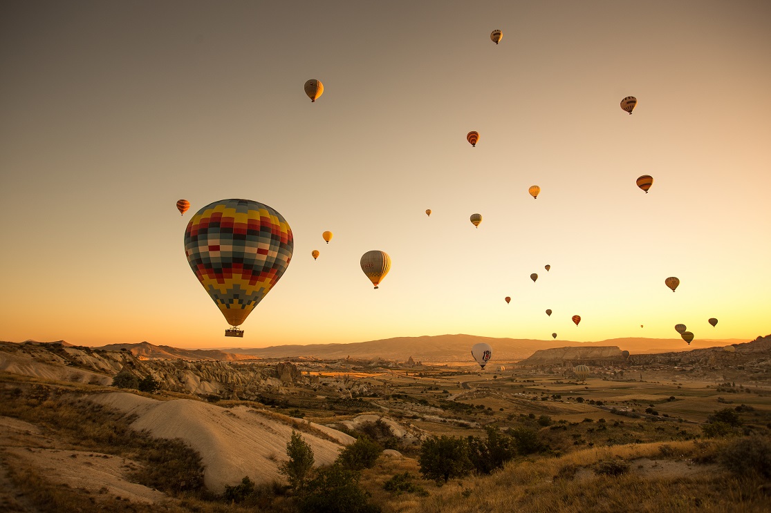 A set of colored balloons flying above the ground in Cappadocia, Turkey
